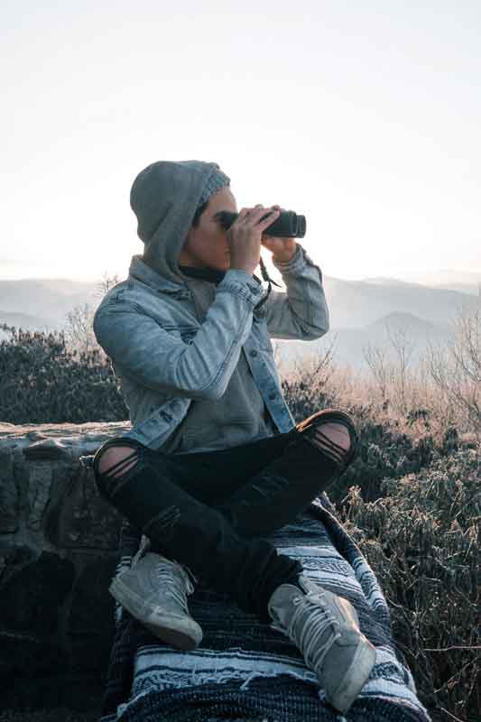 homme en montagne avec des jumelles